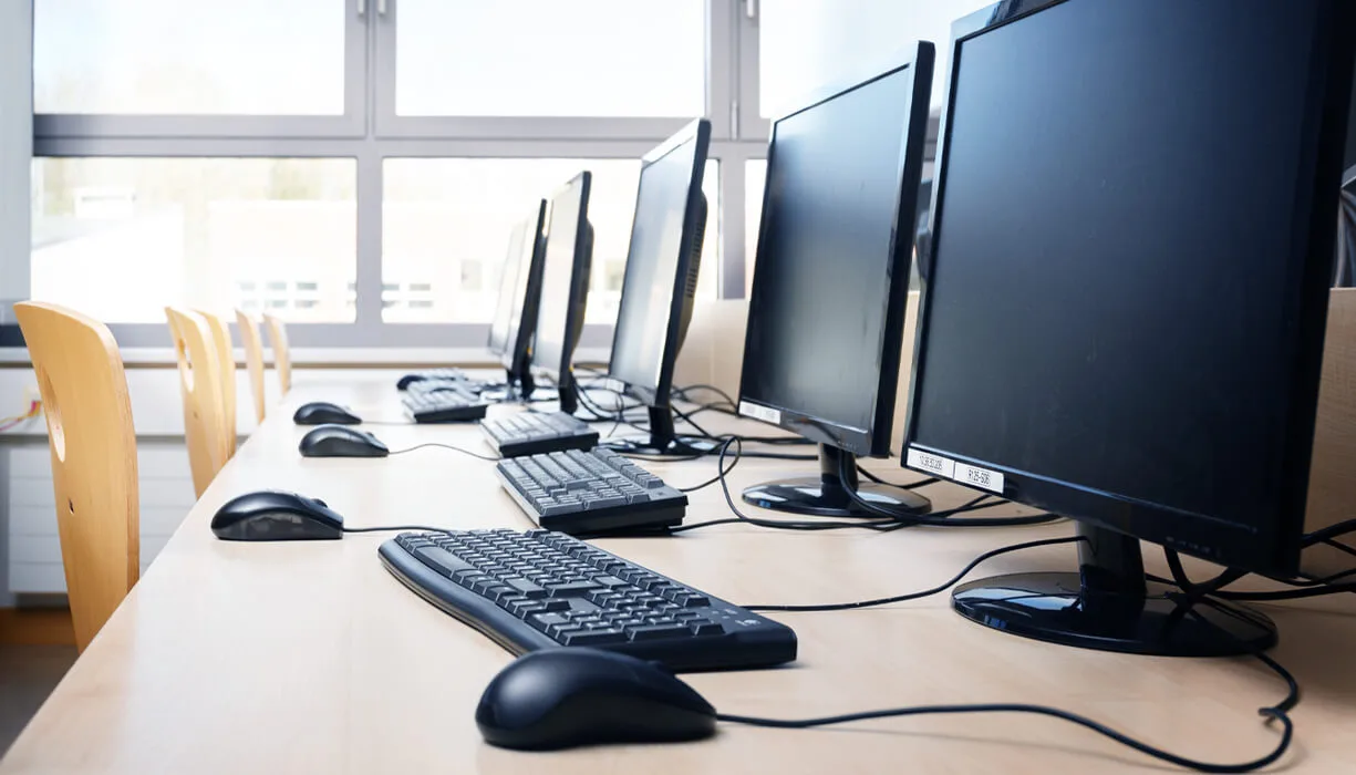 Classroom setup for alcohol education classes, featuring a row of desks each equipped with a computer and keyboard.